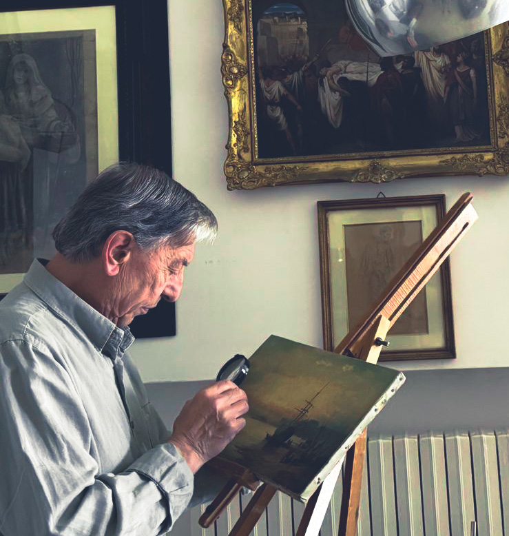 Professor Mimmo Dattoli examining a painting with a magnifier lens under a vintage floor lamp